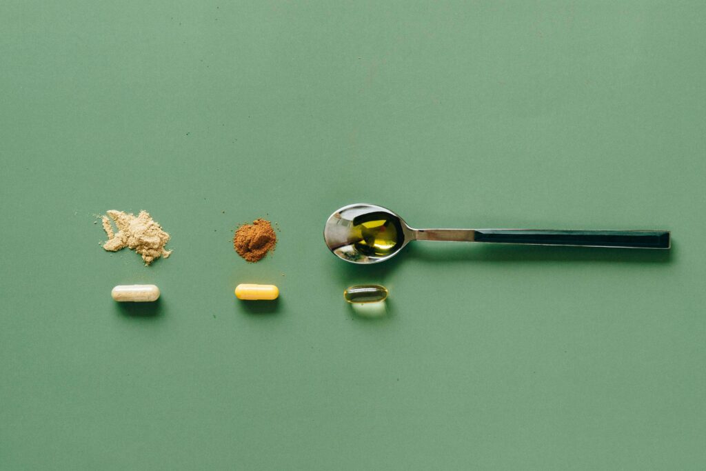 Flat lay de suplementos para a saúde sexual do casal, incluindo Maca Peruana em pó, Tribulus Terrestris e cápsulas sobre um fundo verde.