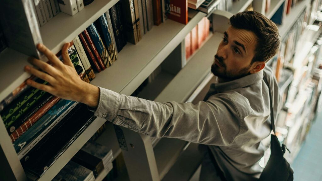 Homem elegante e pensativo, representando o leitor do post sobre livros para o desenvolvimento masculino no blog Refúgio de Vênus.